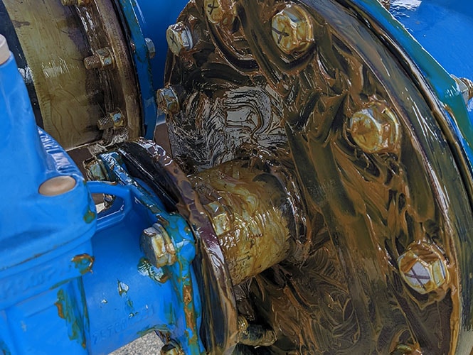 Denso MP Primer applied to a pipe flange and bolts before wrapping